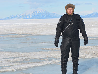 Dr. Amanda Kelley standing on the sea ice after a research dive in McMurdo Sound, Antarctica.