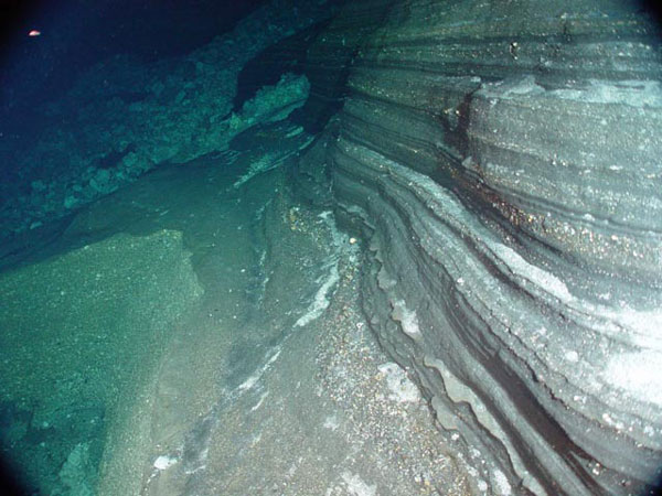 Interlayered basaltic (dark) and felsic (light) ash layers in the east wall of West Rota caldera.