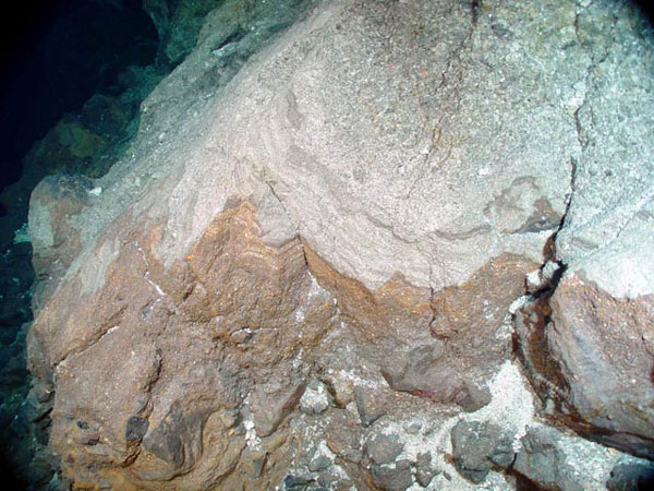 A contact between the lower basaltic and upper felsic ash units in the wall of the West Rota caldera.