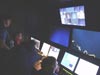 Kari Heinonen, Mike McKee and Dr. Scott France watch from inside the control van as ROV Hercules manipulator arm Predator takes a sample from Bear Seamount.