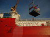 The midnight sun casts spectacular shadows on the HEALY's hull during personnel and equipment retrieval.