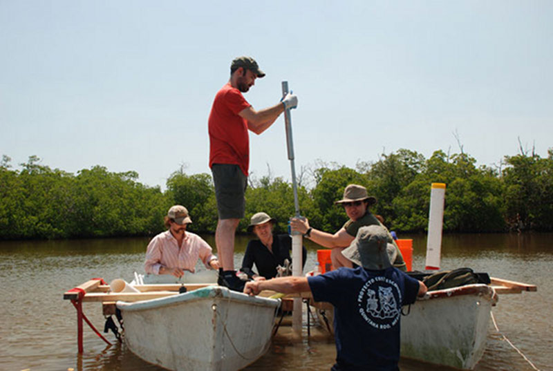 Using PVC piping and a hammering device fabricated by Freddy Flores, the team sinks a core in the West Harbor.