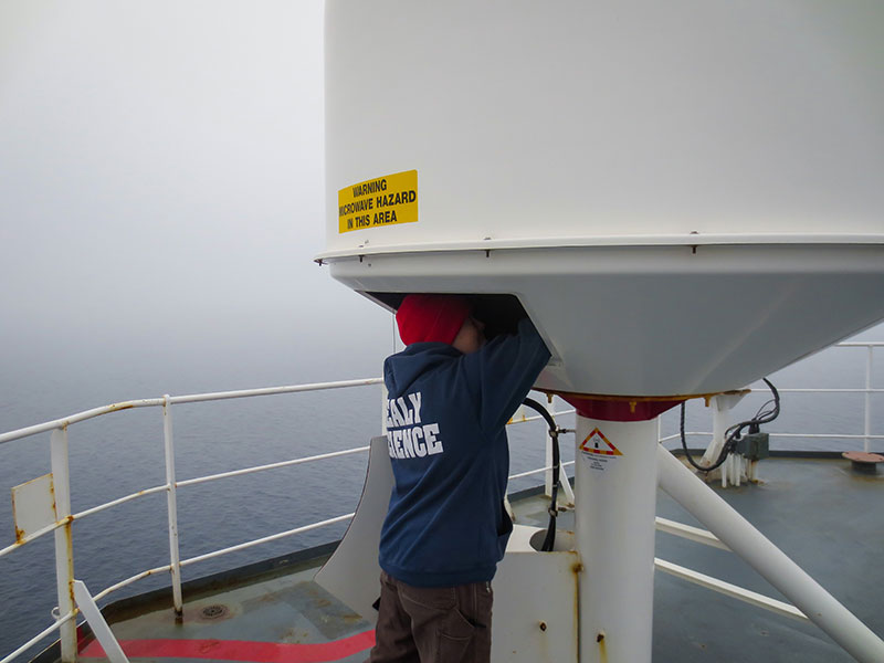 Sarah Kaye works on a satellite dish inside a dome on the top deck of the U.S. Coast Guard Cutter Healy. One of the most prevalent challenges of getting an Internet signal in the Arctic is overcoming atmospheric conditions, such as fog.