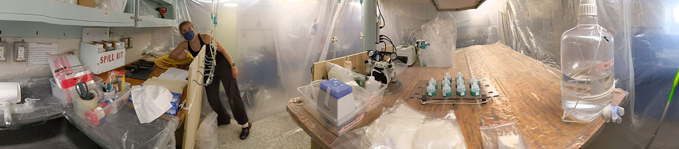 Laura Moore, a doctoral candidate at the University of Washington School of Oceanography, in the trace metal clean bubble to process water samples from the CTD and remotely operated vehicle Jason during the Escanaba Trough: Exploring the Seafloor and Oceanic Footprints expedition.