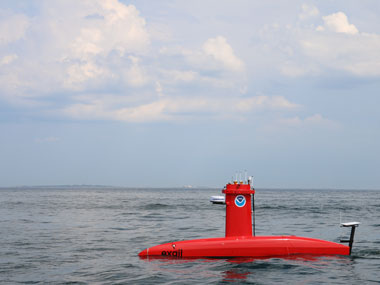 A DriX uncrewed surface vehicle surveys at sea.