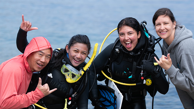 Students and staff participating in scientific dive training pose for the camera.