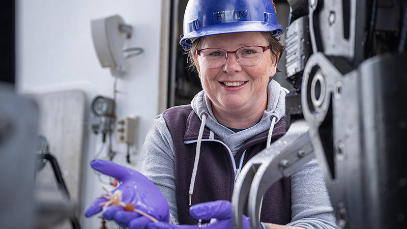 Rhian Waller is seen holding a biological sample during an expedition aboard NOAA Ship Okeanos Explorer.