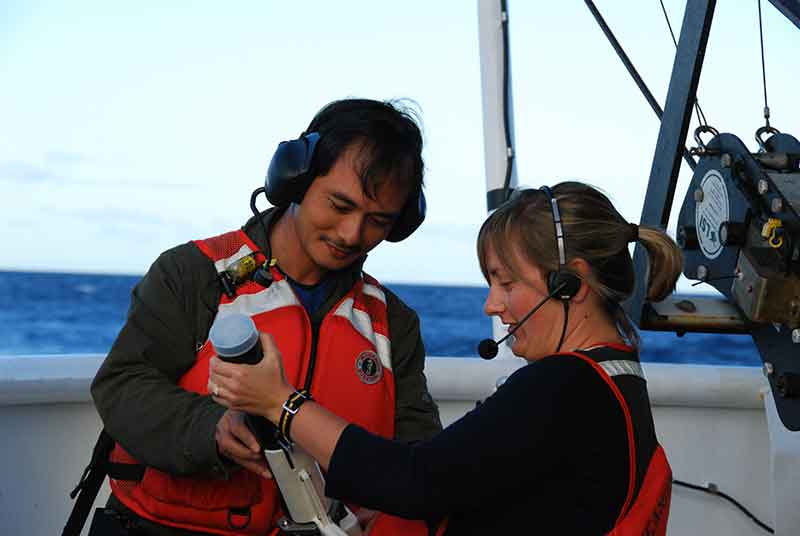 Physical Scientist Meme Lobecker teaches Indonesian scientist Cecep Sujana how to conduct an XBT cast. The XBT measures temperature through the water column. The XBT software calculates sound velocity, which is applied to the Multibeam data for accurate measure of bathymetry.