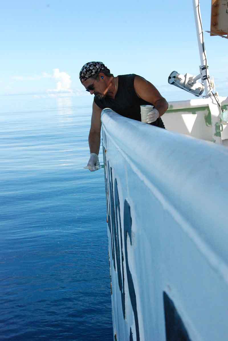 General vessel assistant Jack Standfast primes rust spots on the bulwarks of the aft deck in preparation for painting them white to blend in with the rest of the hull. This is a typical task for members of the deck department, who maintain the outer decks and structures of the ship.