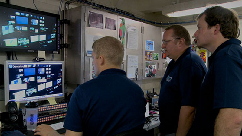 Video team lead Webb Pinner showing recently collected video footage to two members of the science party.