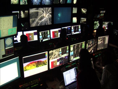 The control room on NOAA Ship Okeanos Explorer as ROV Deep Discoverer (D2) images a crinoid at Northern Forearc Ridge. In the bottom left of the image you can see the newly acquired multibeam bathymetry. Those data were collected, processed, reviewed, and prepped for ROV navigation to guide D2 within 12 hours.