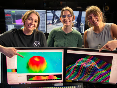 Alex Dawson, Jordan Schweizer, and Teodora Mitroi with bathymetry of a caldera that was mapped south of Hawai‘i during the Beyond the Blue: Hawai‘i Mapping expedition. The expedition focused on the collection of bathymetric, sub-bottom, and water column data in waters deeper than 200 meters (656 feet) within the U.S. Exclusive Economic Zone surrounding the Hawaiian Islands.