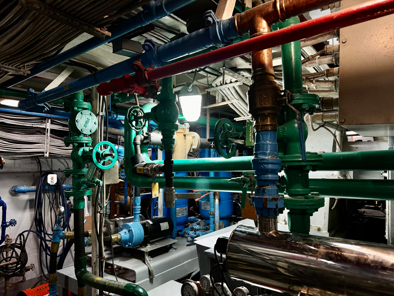 Image of another portion of the engine room of NOAA Ship Okeanos Explorer. The different colored pipes correspond to their different functions.